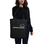 A logo for the classic EPCOT attraction, Horizons, text displaying with a sharp horizon line running through it, gradient to sky above and earth below., on a Black tote — worn stylishly by a model