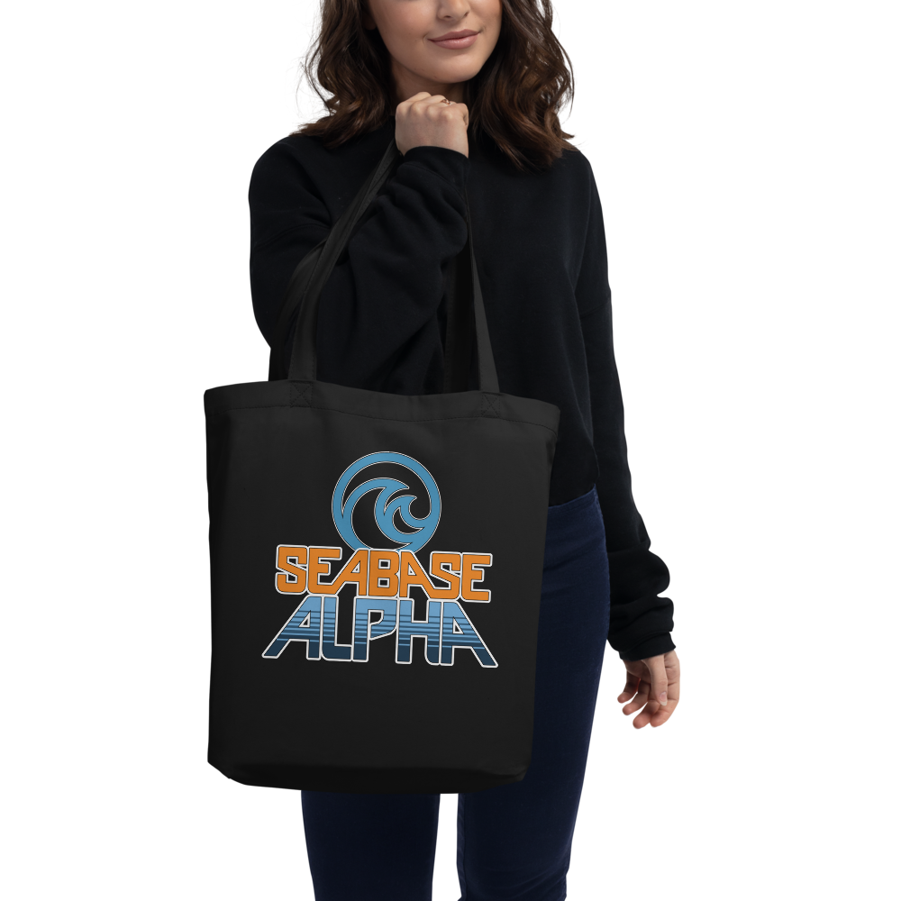 Orange and blue SeaBase Alpha logo with The Living Seas Pavilion icon above, on a Black tote — worn stylishly by a model