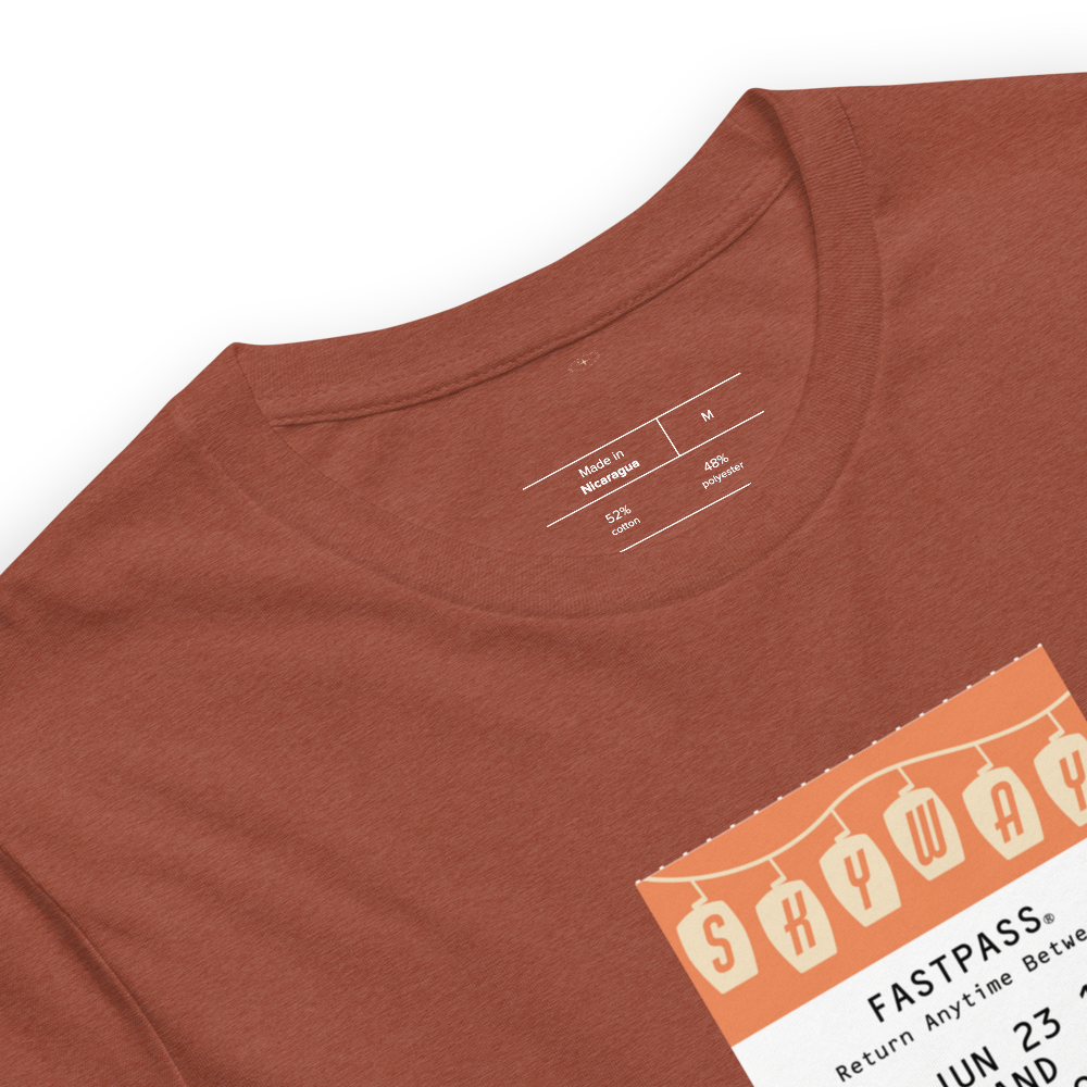 Imagined FASTPASS designed for the Skyway transportation system, with retro orange-toned attraction logo, on a tee — fabric detail